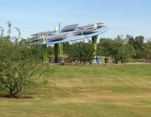 Far view of picnic tables and shade cover at a park