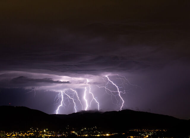 Lightning bolt across a desert mountain sky. surge protection for buildings during storms.