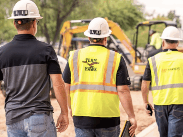 Three employees walking on a job site